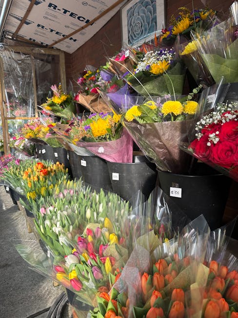 A display of fresh floral arrangements and bouquets at Wealdstone station florist pick up points, Harrow Weald, showcasing a vibrant variety of flowers. The bouquets include yellow chrysanthemums, pur